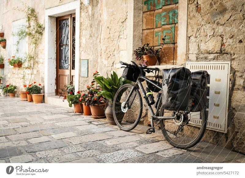 Bicycle with packed bags in a picturesque alley in a southern European town Bicycle tour Cycling tour bike packing vacation Southern European urban Movement