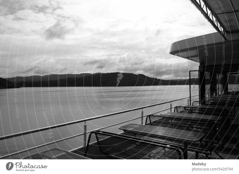 Tables and benches on the deck of an excursion boat overlooking the Edersee near Waldeck in the district of Waldeck-Frankenberg in Hesse in neo-realistic black and white
