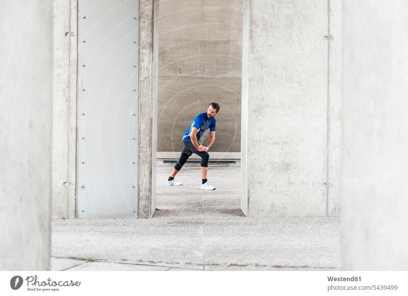 Man stetching at an underpass man men males stretching Adults grown-ups grownups adult people persons human being humans human beings athlete Sportspeople