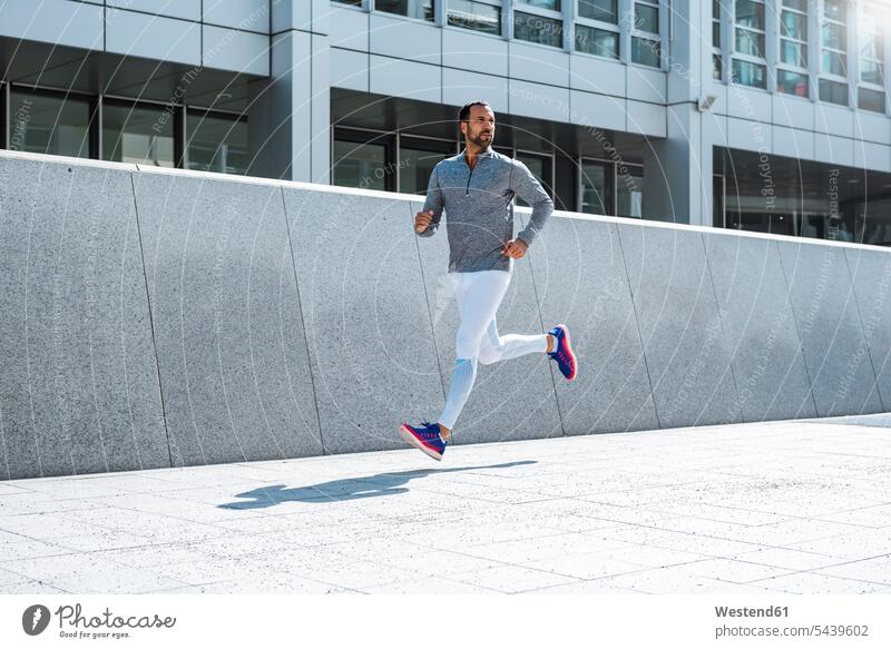 Man running in the city town cities towns man men males outdoors outdoor shots location shot location shots Adults grown-ups grownups adult people persons