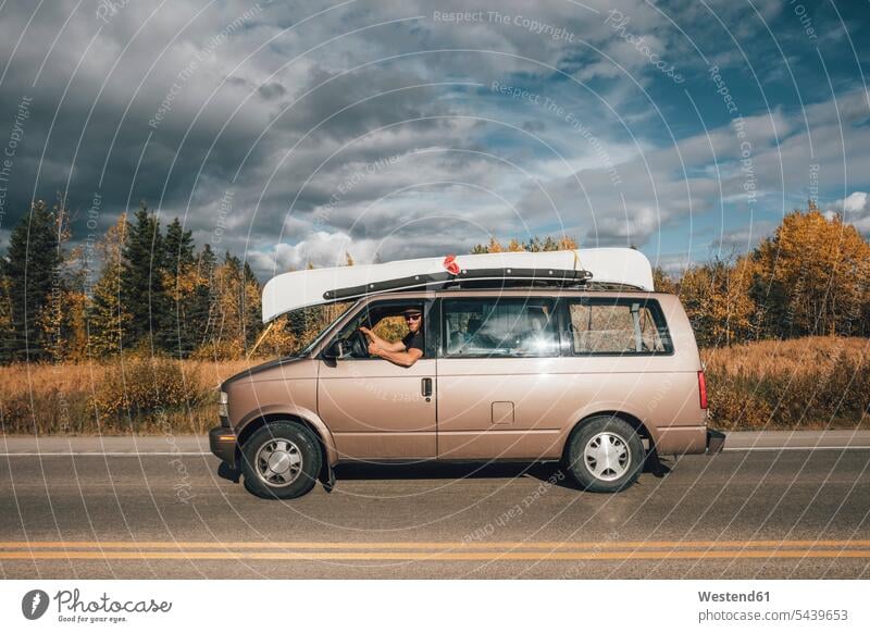 Canada, British Columbia, man with minivan on Alaska Highway Minivan Mini Van men males car automobile Auto cars motorcars Automobiles highway Highways Adults
