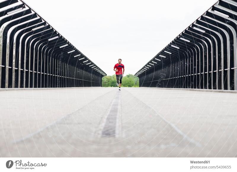 Man running on a bridge man men males bridges Adults grown-ups grownups adult people persons human being humans human beings Germany sky skies training