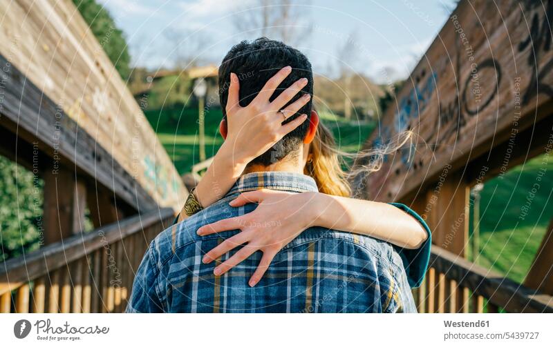 Back view of young man kissed by his girlfriend lovers couple twosomes partnership couples people persons human being humans human beings embracing embrace