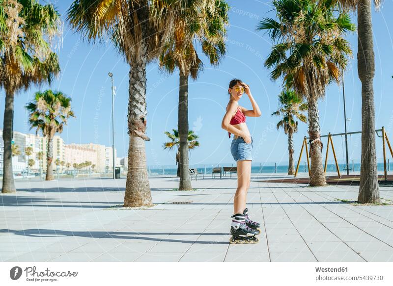 Young woman on inline skates on boardwalk with palm trees inliners females women Palm Palm Trees Palms Rollerblades inline skating rollerskating roller skating