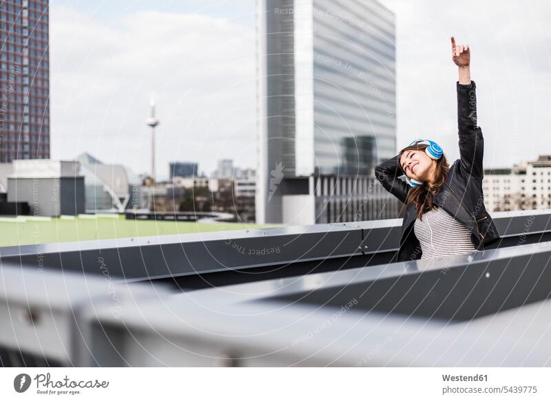 Young woman in the city wearing headphones, dancing caucasian caucasian ethnicity caucasian appearance european copy space Architecture skyscraper skyscrapers