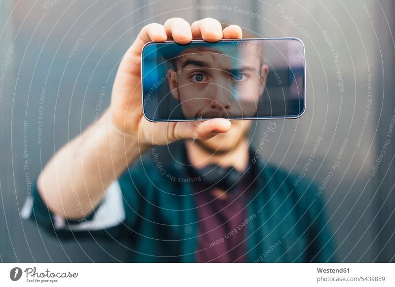 Display of smartphone showing young man pulling funny face - a Royalty ...