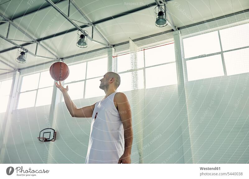 Man playing with basketball, indoor Basketball balancing balance turning hand human hand hands human hands recreational exercises leisure time sports