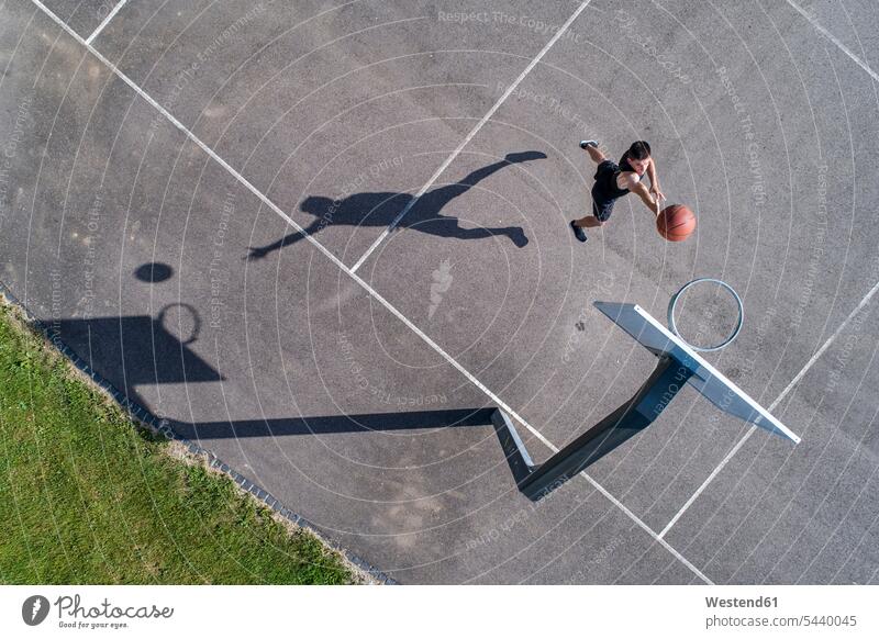 Aerial view of young man playing basketball Basketball throwing dunk slam dunk slam shot Dunking basketball hoop backboard basketball hoops sport sports