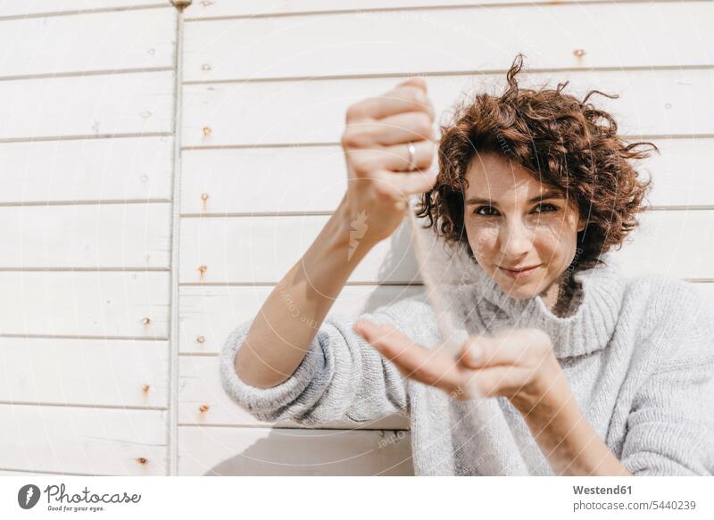 Woman trickling sand through her hands woman females women sandy Adults grown-ups grownups adult people persons human being humans human beings vacation