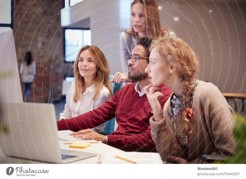 Colleagues looking over shoulder of young man working in modern office Female Colleague watching offices office room office rooms At Work team PC desktop PC