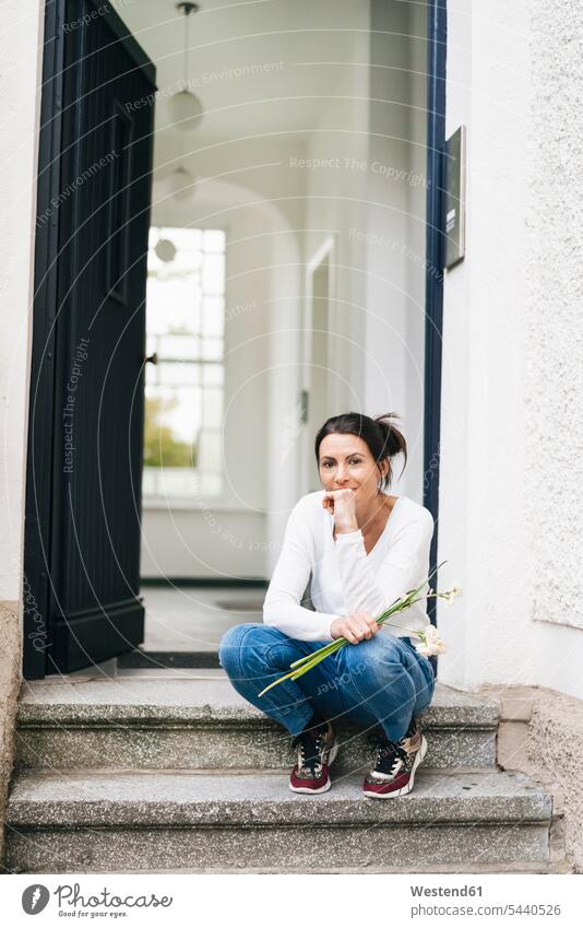 Woman with flowers sitting on doorstep Flower Flowers Doorstep Seated woman females women Adults grown-ups grownups adult people persons human being humans