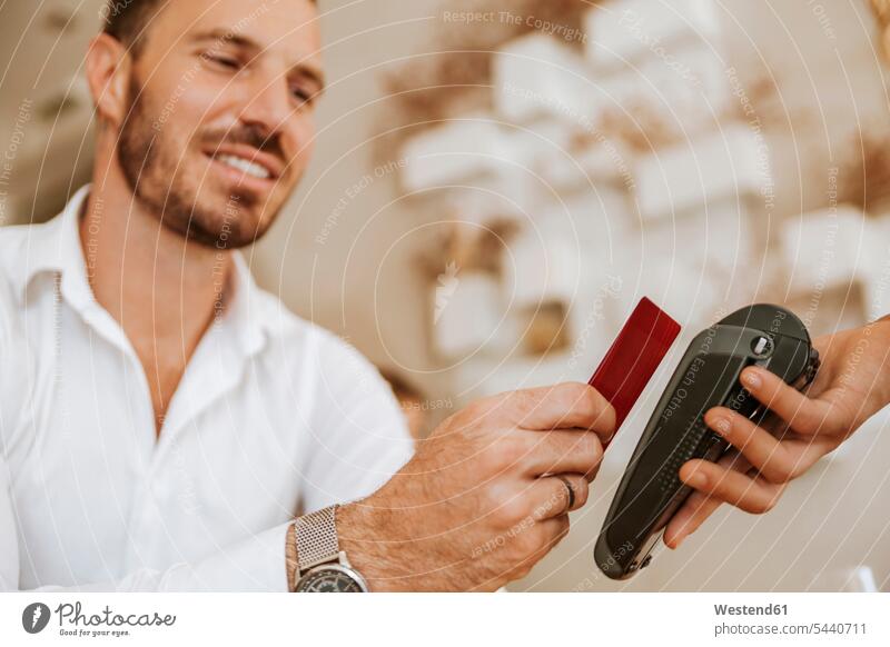 Smiling man paying contactless in cafe smiling smile payment technology technologies Technological beard contactless payment Joy enjoyment pleasure Pleasant