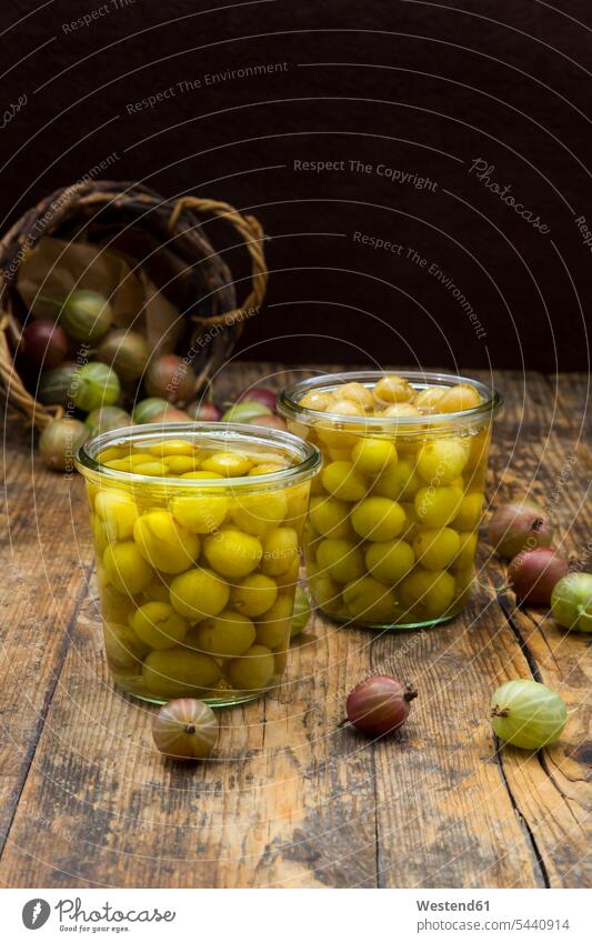 Two jars of preserved gooseberries and gooseberries on wood basket baskets large group of objects many objects uncooked homemade home made home-made confected