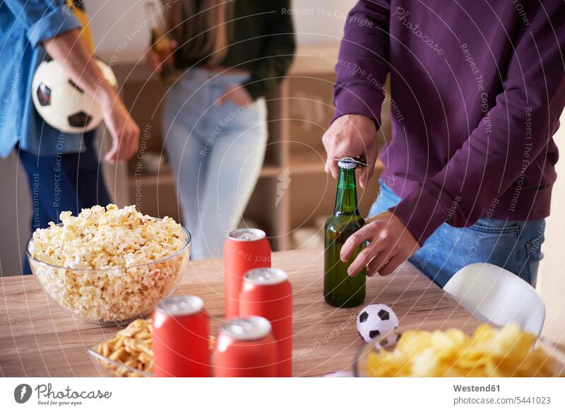 Football fan opening a bottle of beer Beer Beers Ale relaxed relaxation admirer fans Beer Bottle Beer Bottles Alcohol alcoholic beverage Alcoholic Drink