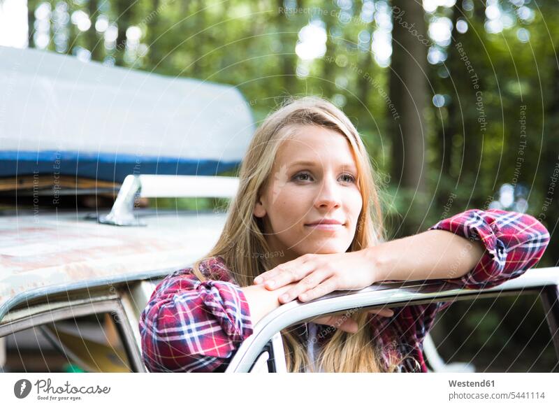 Smiling young woman at car in forest automobile Auto cars motorcars Automobiles smiling smile woods forests females women motor vehicle road vehicle