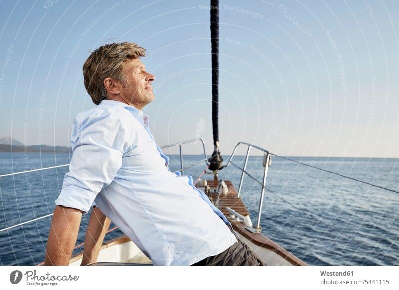 Mature man relaxing on his sailing boat men males Adults grown-ups grownups adult people persons human being humans human beings boat sports boats sailor