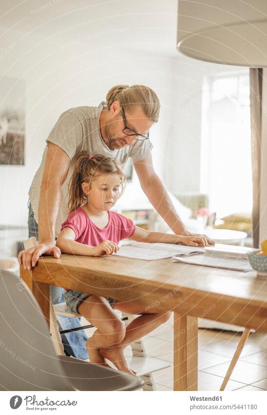 Father checking homework of his daughter daughters father pa fathers daddy dads papa Home work child children family families people persons human being humans