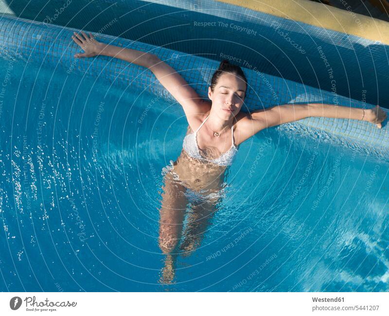 Portrait of plump young woman relaxing in swimming pool - a