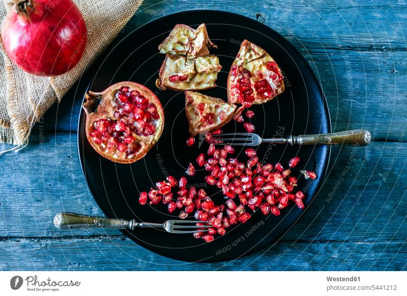Half of pomegranate, pomegranate seed and two old forks on black plate nobody preparation prepare preparing Fork Forks Freshness fresh healthy eating nutrition