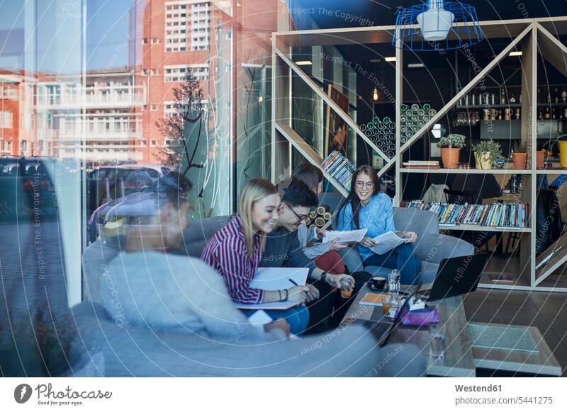 Group of friends sitting together in a cafe with reflection of glass pane Seated window windows glass panes friendship Connection connected Connections