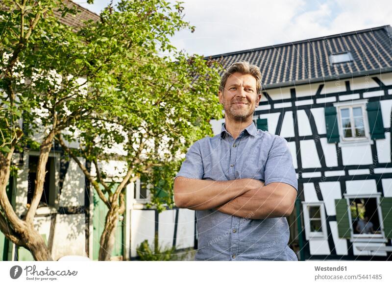 Mature man standing in his garden wearing apron smiling smile arms crossed Arms Folded Folded Arms Crossed Arms Crossing Arms Arms Clasped owner owners gardens