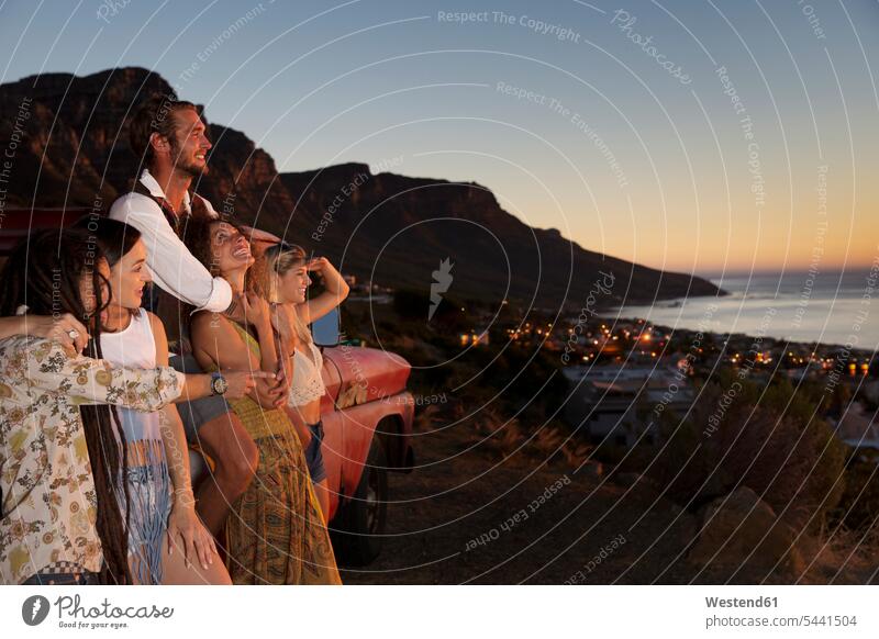 Young people outside pick up truck at the coast enjoying the sunset friends Fun having fun funny coastline shoreline friendship alternative lifestyle