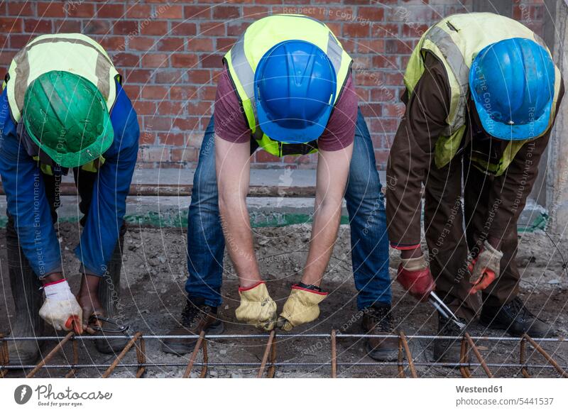 Construction workers on a construction site assembling reinforcing steel colleagues working At Work building Building Site sites Building Sites