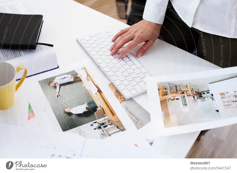 Close-up of woman holding photography and using computer keyboard in office desk desks businesswoman businesswomen business woman business women offices