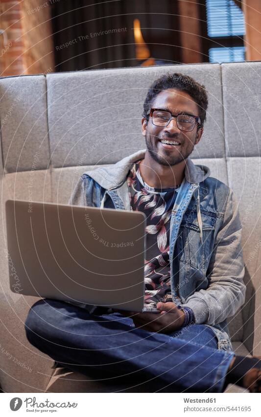 Young man working in creative start-up company, using laptop office offices office room office rooms young man young men creative professional Creative People