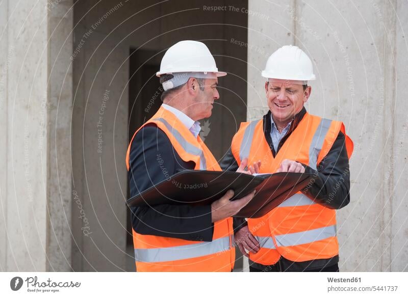 Two Men In Hard Hats At Construction Site Stock Photo, Picture and