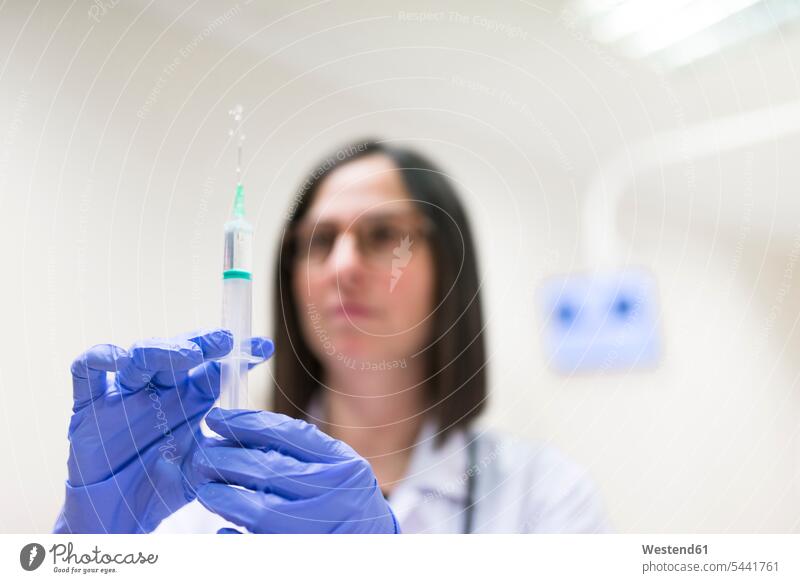 Close-up of doctor preparing syringe glove gloves Female Doctor physicians Female Doctors protective glove protective gloves woman females women doctors