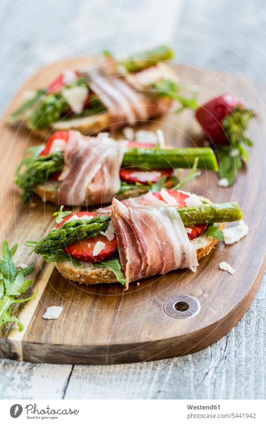 Baguette with strawberries, rocket, asparagus, pecorino flakes and bacon food and drink Nutrition Alimentation Food and Drinks wooden board wooden boards