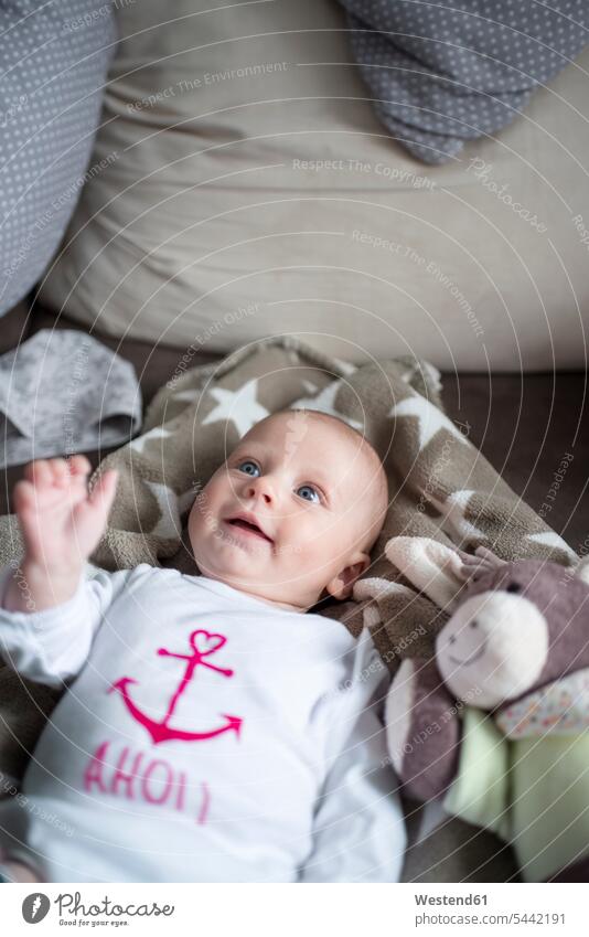 Portrait of smiling baby girl lying on a couch infants nurselings babies baby girls female portrait portraits people persons human being humans human beings