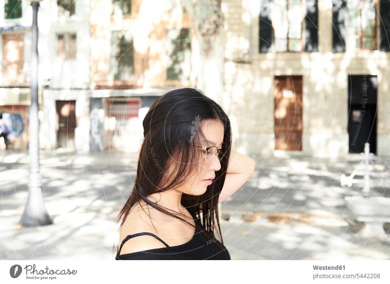 Thoughtful pretty asian woman in the street wearing glasses female Asian female Asians long hair longhair long-haired serious earnest Seriousness austere