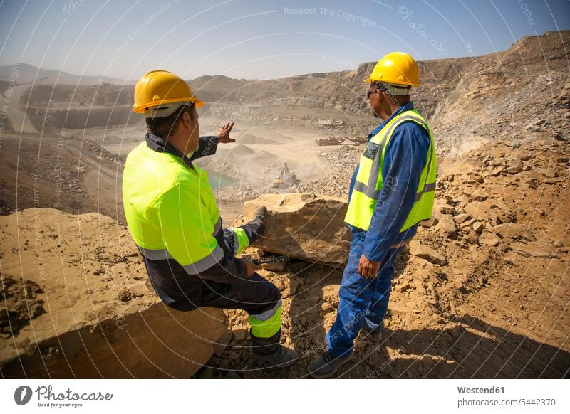Two quarry workers looking over quarry open-pit mining surface mine surface mining strip mining Open-Pit Mine opencast mining gravel pit protective clothing