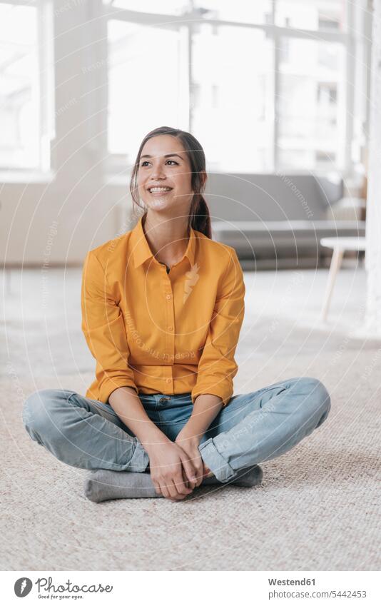 Young woman sitting on floor, smiling females women young cheerful gaiety Joyous glad Cheerfulness exhilaration merry gay carpet carpets rug rugs Adults