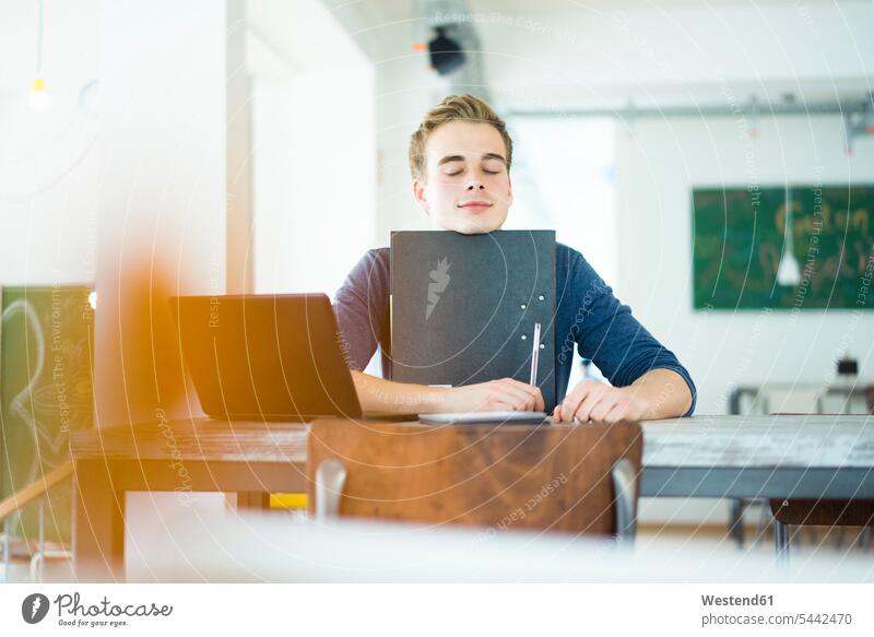 Portrait of student with laptop and file in a coffee shop portrait portraits students break man men males cafe learning Laptop Computers laptops notebook Adults