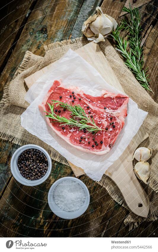 Raw beefsteak with rosemary, salt and pepper Chopping Board Cutting Boards Chopping Boards greaseproof paper waxed paper ingredient ingredients Pepper