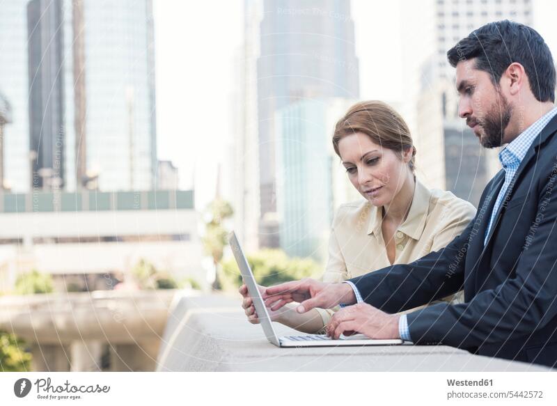 Businessman and businesswoman using laptop together Laptop Computers laptops notebook colleagues computer computers business world business life businesswear