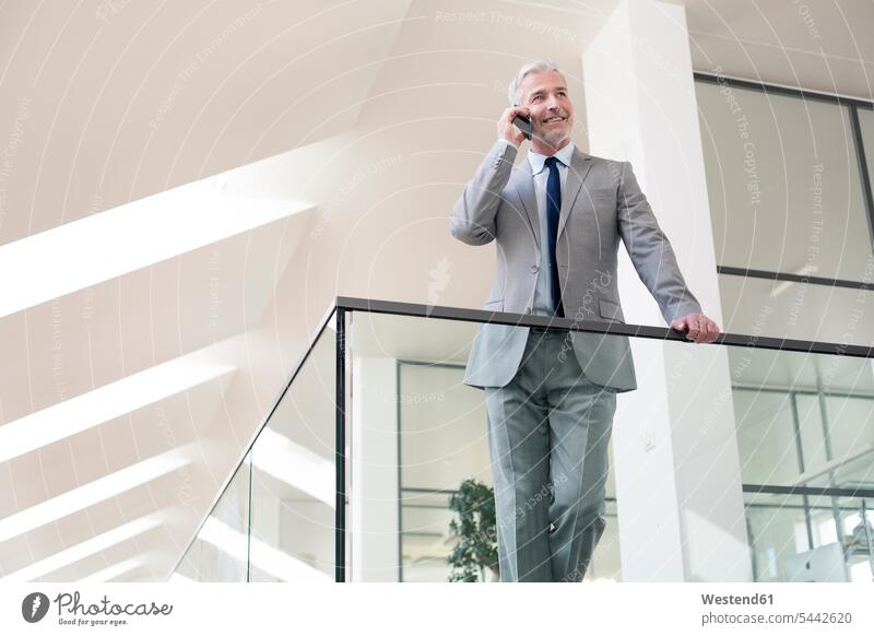 Businessman standing in office using his mobile phone Success successful Business man Businessmen Business men on the phone call telephoning On The Telephone