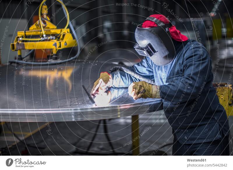 Worker welding in factory working At Work man men males welder Adults grown-ups grownups adult people persons human being humans human beings industry