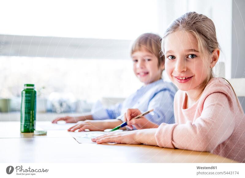 Brother and sister painting at table sisters brother brothers smiling smile siblings brother and sister brothers and sisters family families people persons