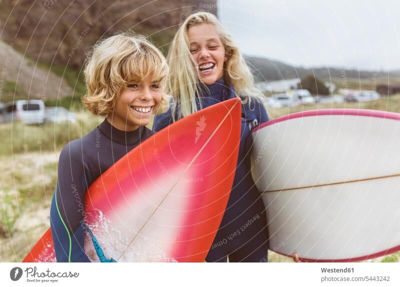 Spain, Aviles, portrait of two happy young surfers on the beach surfboard surfboards Teenager Teens teenagers smiling smile beaches surfing surf ride