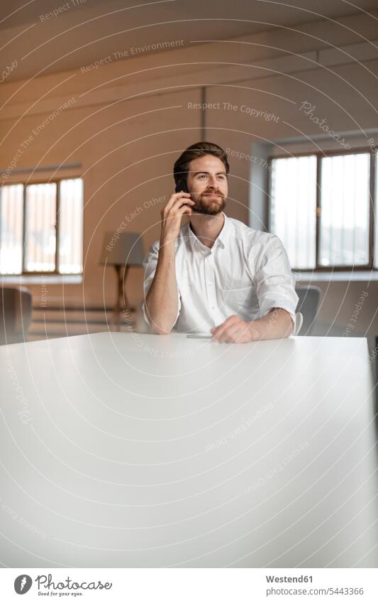 Portrait of young freelancer on the phone in a loft freelancing call telephoning On The Telephone calling telephone call Phone Call using phone Using Phones