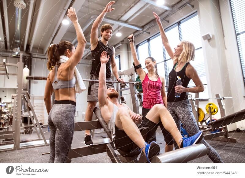 Happy, healthy group of people with arms in the air at a gym Stock Photo -  Alamy