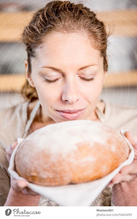 Woman holding loaf of bread woman females women Bread Breads Adults grown-ups grownups adult people persons human being humans human beings Food foods