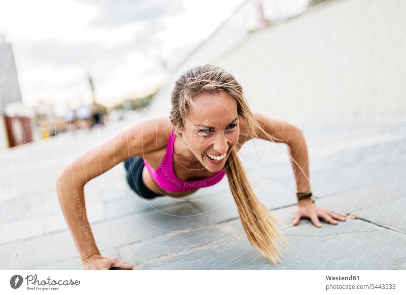 Young woman stretching and warming up for training at the beach exercising exercise practising warm up females women sport sports Adults grown-ups grownups