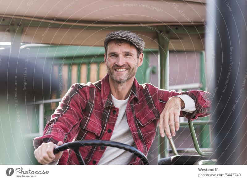 Portrait of confident farmer on tractor smiling smile portrait portraits man men males agriculturists farmers Adults grown-ups grownups adult people persons