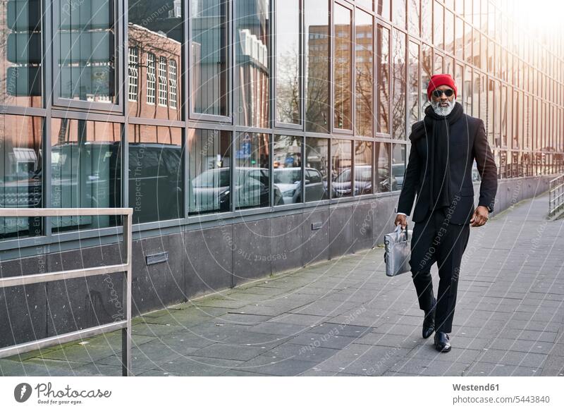 Mature businessman walking in the street going determination decided determined purposeful Decidedness on the move on the way on the go on the road Businessman