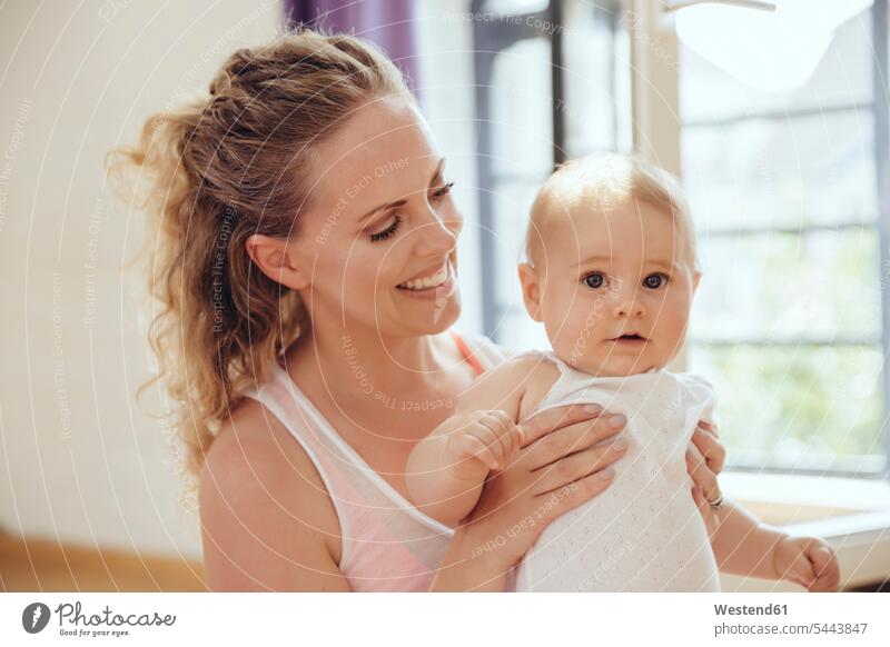 Smiling mother holding her baby portrait portraits infants nurselings babies smiling smile mommy mothers ma mummy mama people persons human being humans